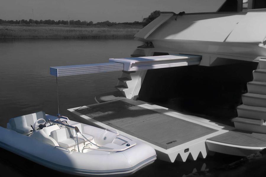 Gru a soffitto di tipo travel installata nel garage di uno yacht, con braccio telescopico in acciaio inox per il sollevamento di tender e moto d’acqua.