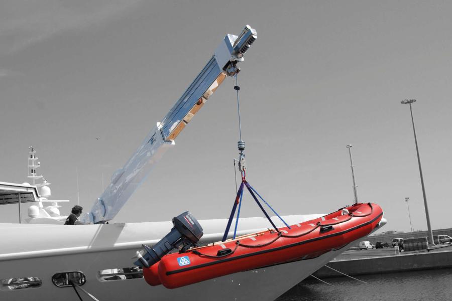 Gruetta elettroidraulica in acciaio inox verniciato con braccio telescopico e gancio di sollevamento, utilizzata per il varo di un tender.