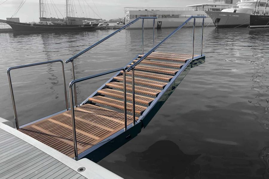 Scala da bagno per yachts in acciaio inox lucidato con gradini autolivellanti in teak, installata sul pontile e immersa in acqua