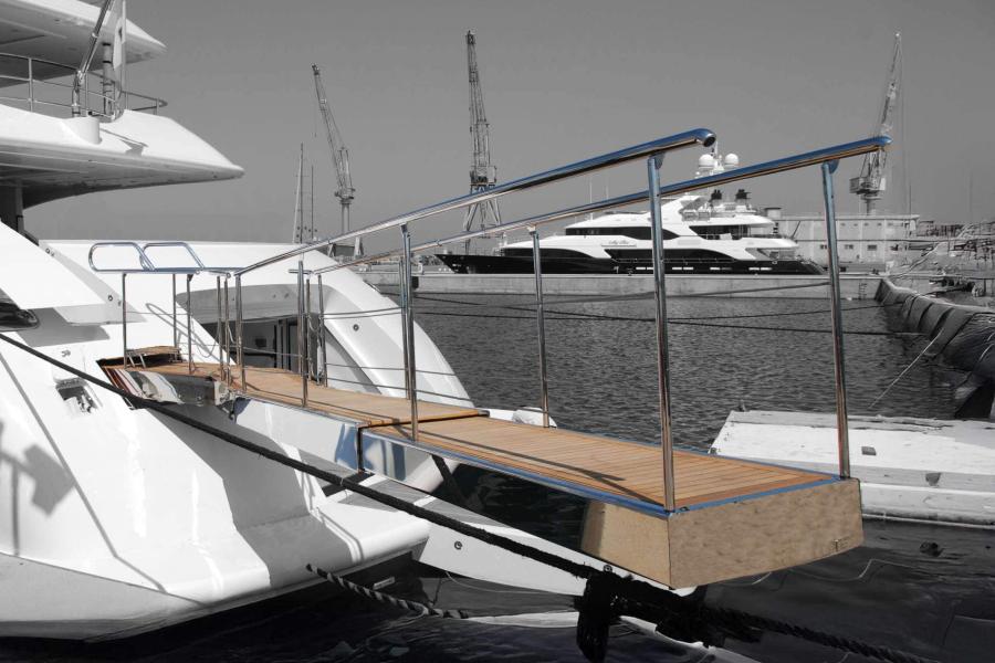 Passerella idraulica telescopica realizzata in acciaio inox con camminamento in teak, installata a poppa di uno yacht di lusso